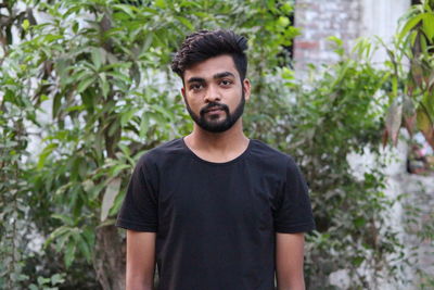 Portrait of man standing against plants