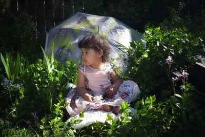 Toddler girl gazing off in flower garden