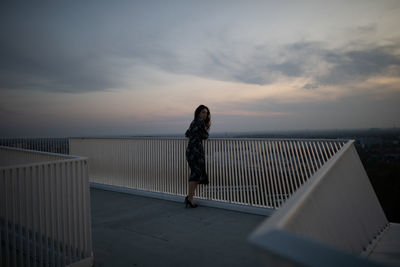 Full length of woman standing against sky during sunset