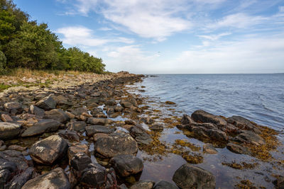 Rocks by sea against sky