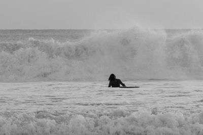 Woman bodyboarding in sea