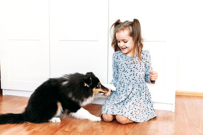 Portrait of a girl with cat on floor