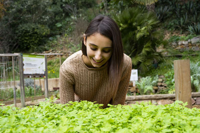 Young woman in front of plants