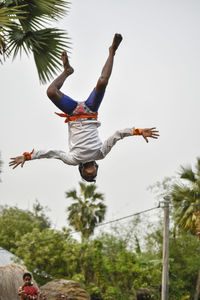 Low angle view of men flying against clear sky