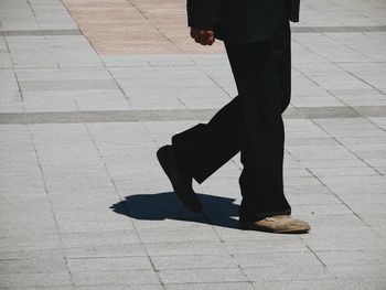 Low section of woman standing on sidewalk