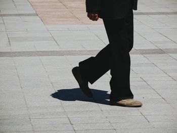 Low section of man walking on street