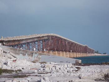 View of abandoned bridge over river against clear sky