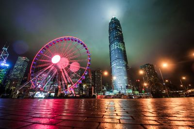 Surface level of illuminated ferris wheel against sky at night