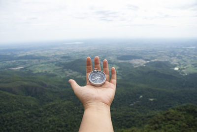 Midsection of person holding umbrella against mountain