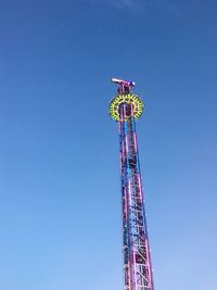 Low angle view of ferris wheel against clear blue sky