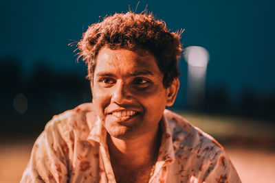 Portrait of smiling young man against blurred background