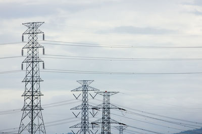 Low angle view of electricity pylon against sky