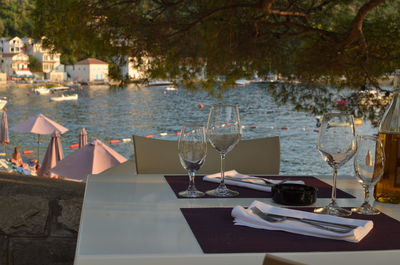 Set table on a seashore restaurant table, with a reservation sign and a boat on sea