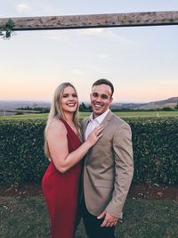 Portrait of smiling young couple standing on field