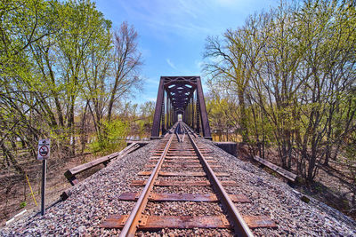 Railroad tracks by trees against sky