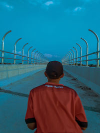 Rear view of woman standing by sea against sky