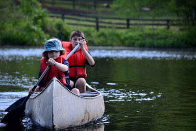 Brothers canoeing on lake