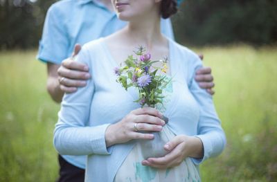 Midsection of couple standing on field