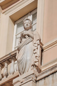 Low angle view of angel statue against wall