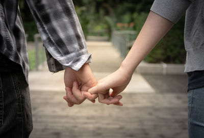 Midsection of couple holding hands