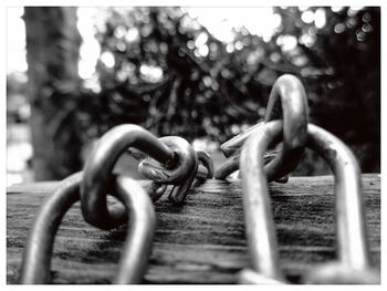 Close-up of metal chain on wooden surface