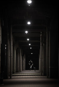 Man walking on illuminated corridor of building