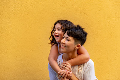 Portrait of happy woman against wall