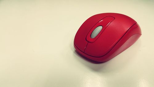 Close-up of red computer mouse on white background