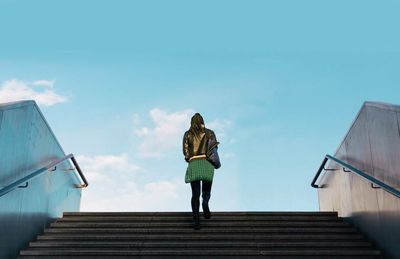 Low angle view of woman standing against clear sky
