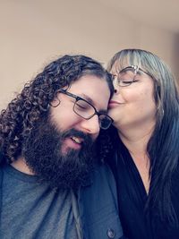 Close-up of woman kissing on man forehead at home