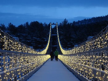 Illuminated bridge against sky at night