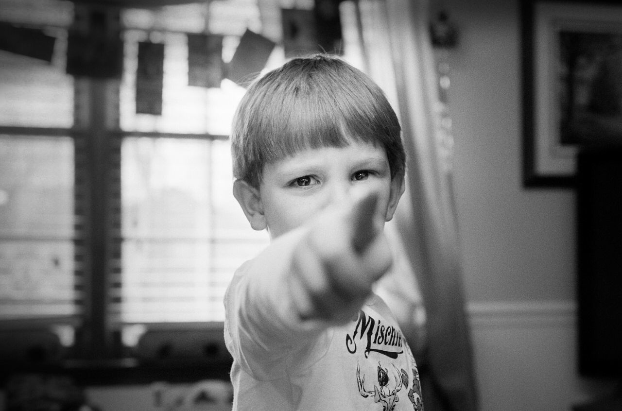 focus on foreground, lifestyles, headshot, person, indoors, front view, leisure activity, portrait, looking at camera, casual clothing, close-up, boys, childhood, head and shoulders, waist up, elementary age, contemplation