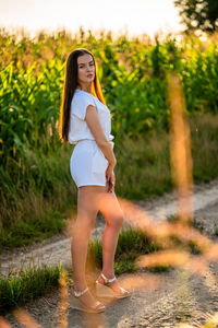 Portrait of young woman standing on field