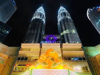 Low angle view of illuminated buildings against sky at night