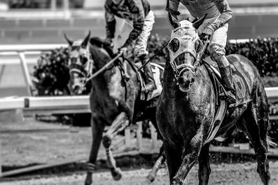 Full length of man riding horse racing 