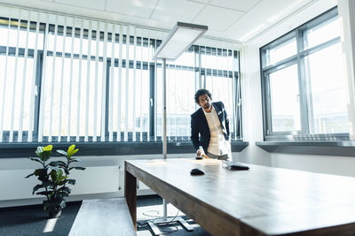 Businessman standing by desk at workplace