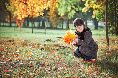 Woman standing by tree during autumn