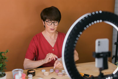 Senior woman filming make-up vlog