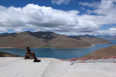 Man riding motorcycle on mountain road against sky
