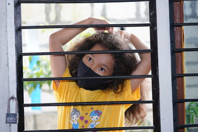 Portrait of cute girl looking through window