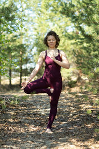 Portrait of young woman exercising on field