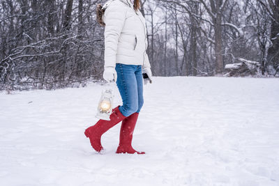 Full length of woman standing on snow covered field