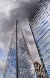 Low angle view of modern building against cloudy sky