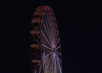 Low angle view of illuminated ferris wheel against sky at night