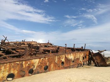 Old ruins on beach against sky