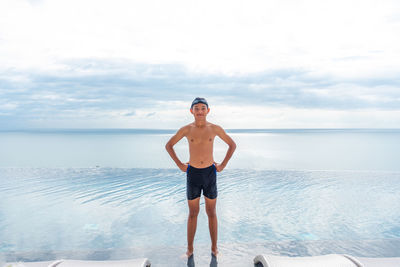 Portrait of man standing in sea against sky