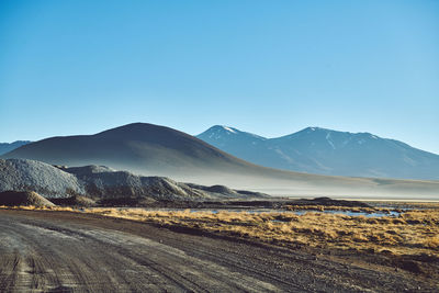 Scenic view of landscape and mountains against clear blue sky