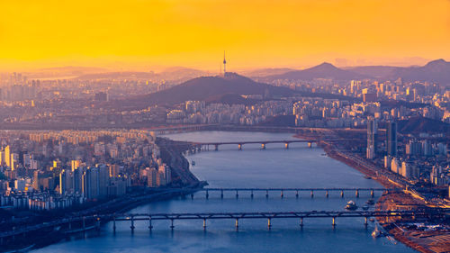 Bridges over river in city during sunset