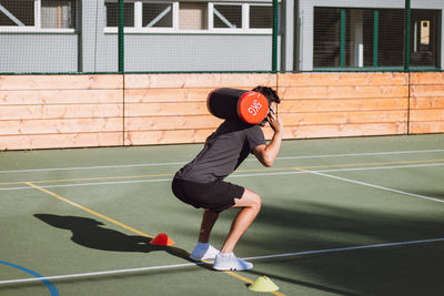 Athlete with a barbell on his back performs a lunge to strengthen the trunk and lower part of body