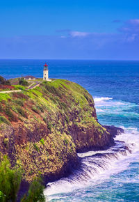 Lighthouse by sea against sky